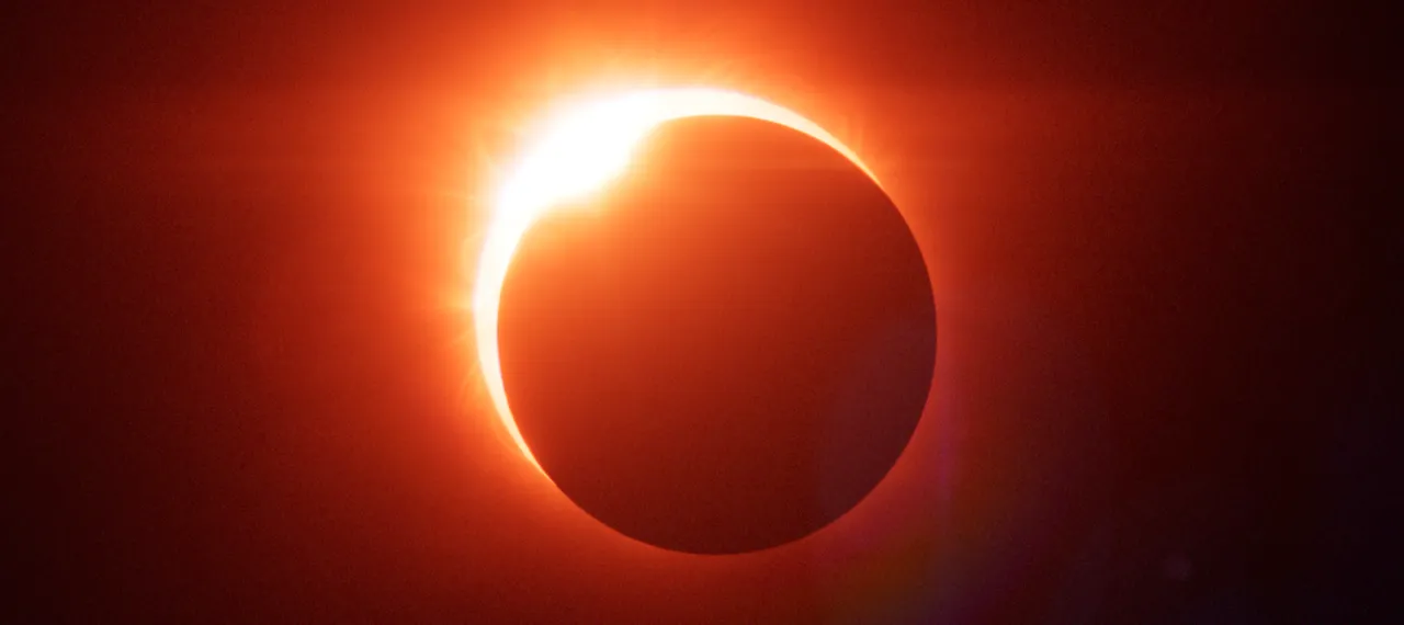 Une éclipse solaire&nbsp;: un disque noir cerclé de protubérances rouges et orange