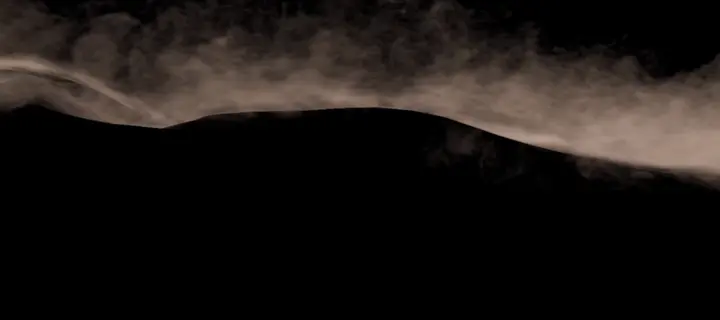Du sable fin soufflé depuis la crête d’une dune lointaine, sur fond noir
