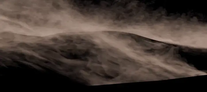 De fines traînées de sable qui fouettent une dune, sur fond noir