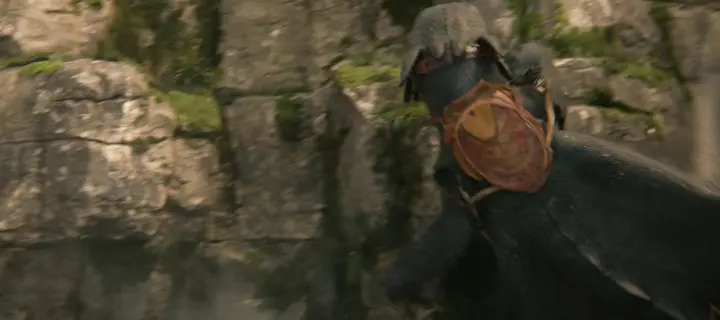 Un dragon noir qui s’écrase contre une paroi de falaise moussue