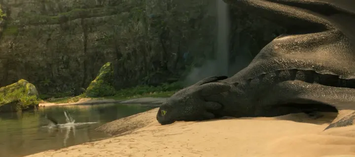 De petites éclaboussures en eau peu profonde, à côté d’un dragon couché sur la plage